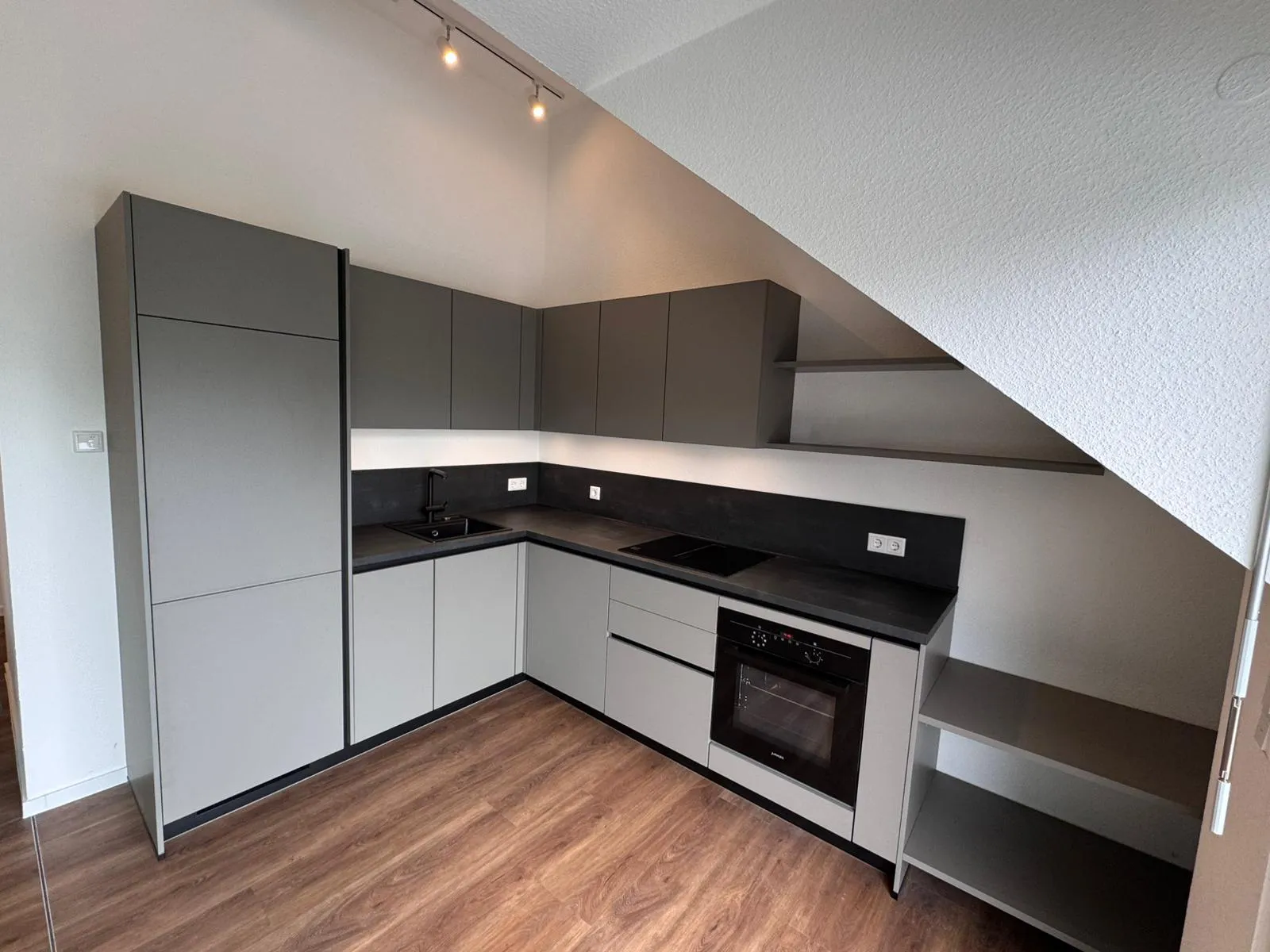 Graue Einbauküche unter Dachschräge mit Backofen – Referenz von SORI Studios